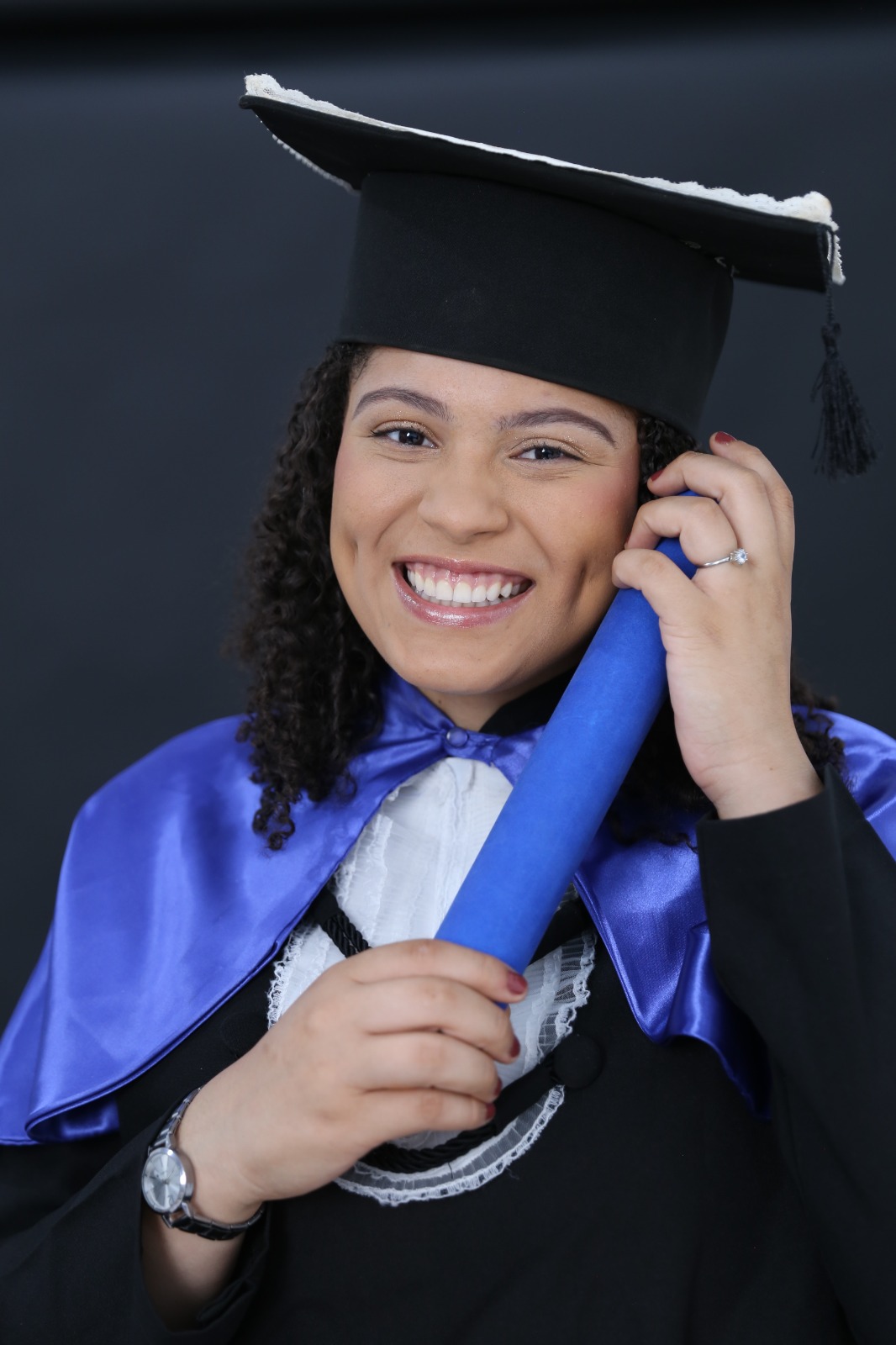 Tauane sorrindo com o capelo de formatura